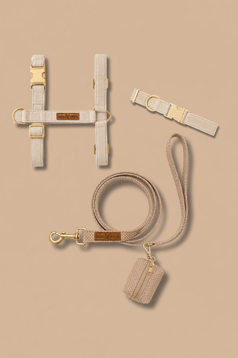 Caden Lane sand dune beige flax fabric pet accessory set including strap harness, collar, leash, and waste bag holder on tan background