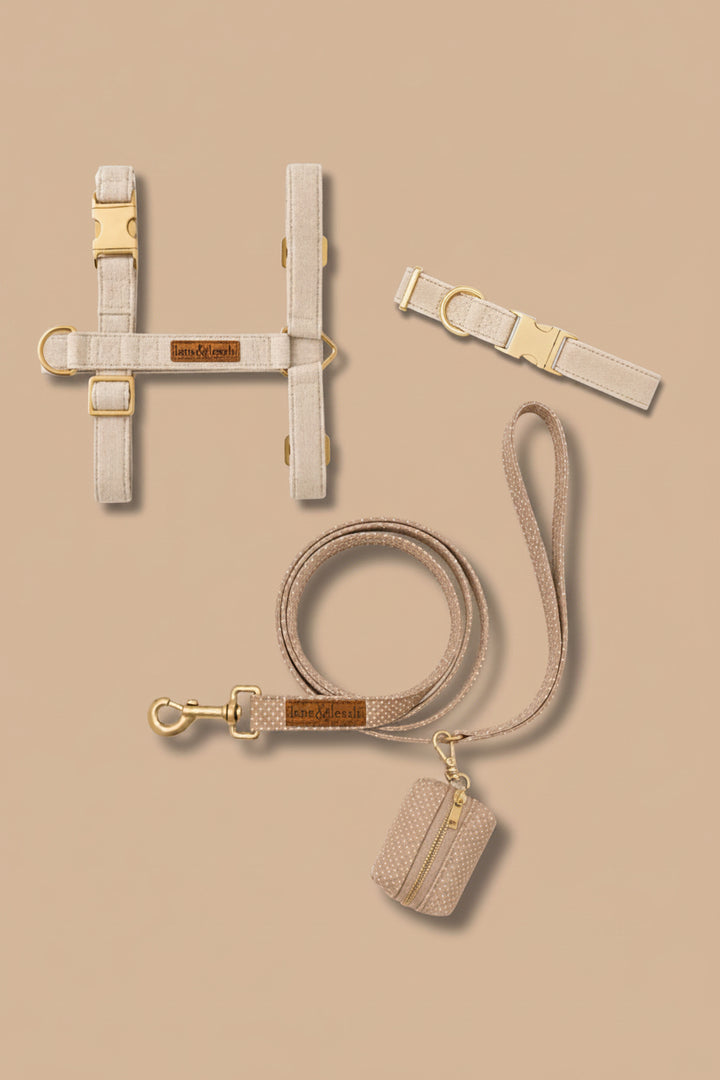 Caden Lane sand dune beige flax fabric pet accessory set including strap harness, collar, leash, and waste bag holder on tan background