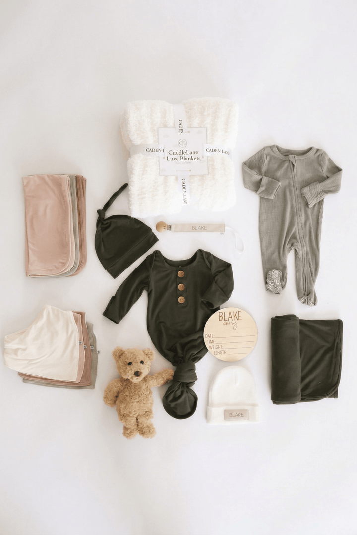 baby shower gift box bundle with neutral earthy tone pajamas, blanket, bear stuffed toy, burps and bibs