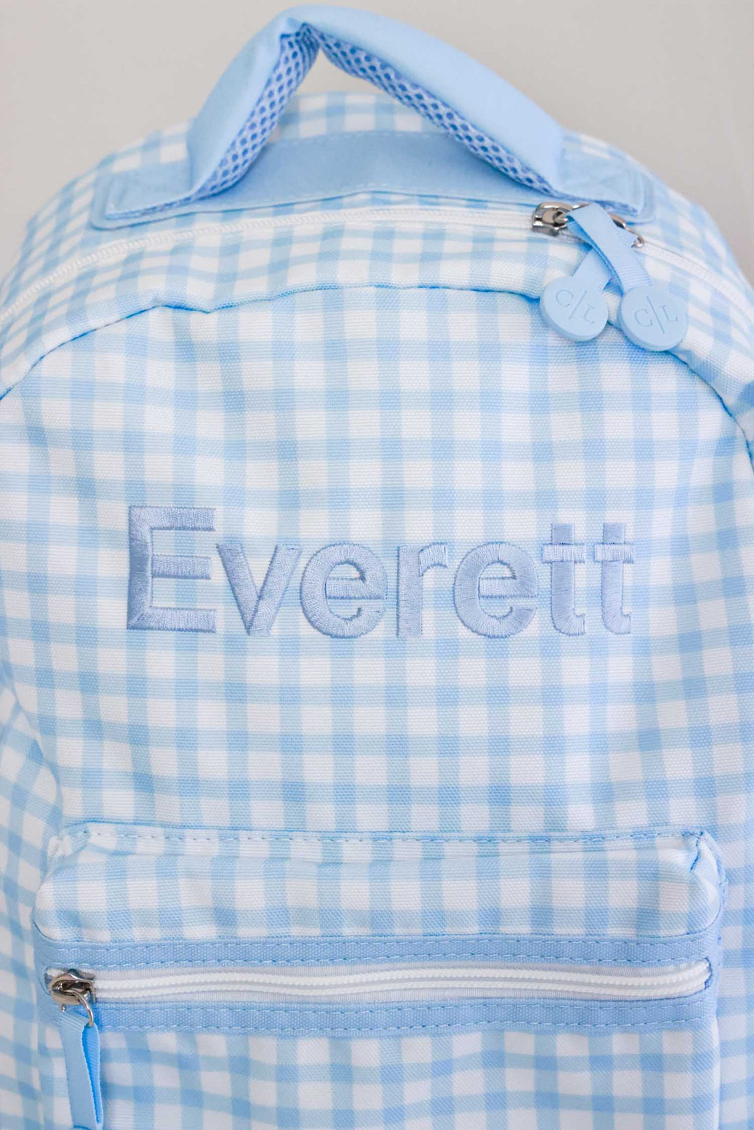 closeup of embroidery on blue gingham backpack