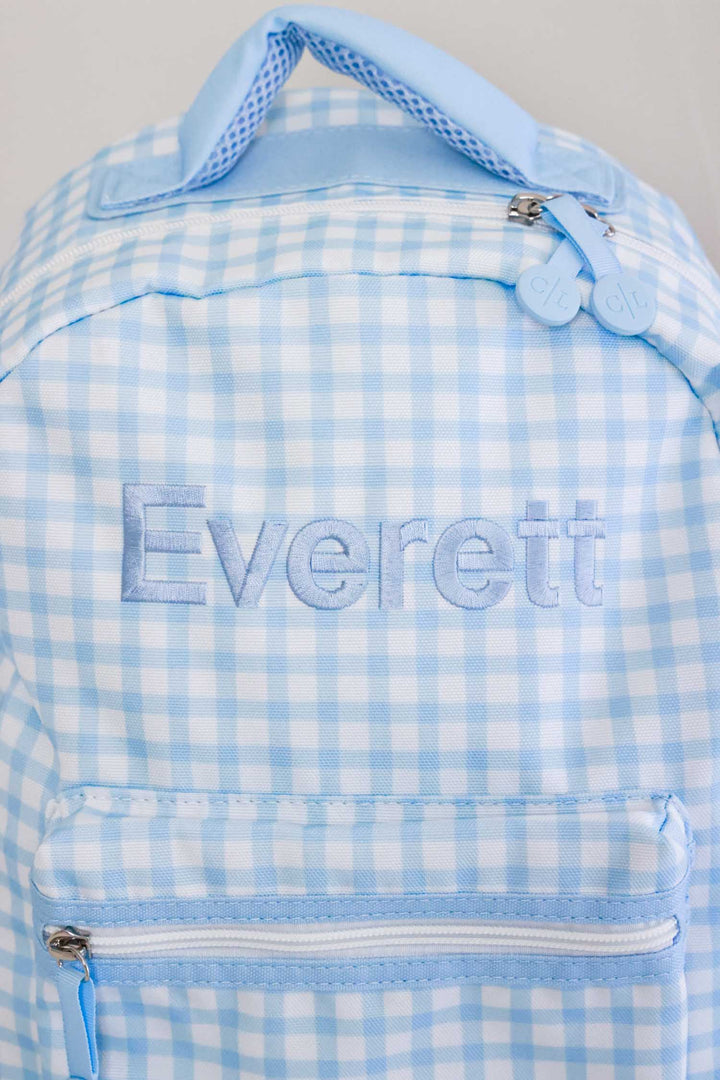 closeup of embroidery on blue gingham backpack