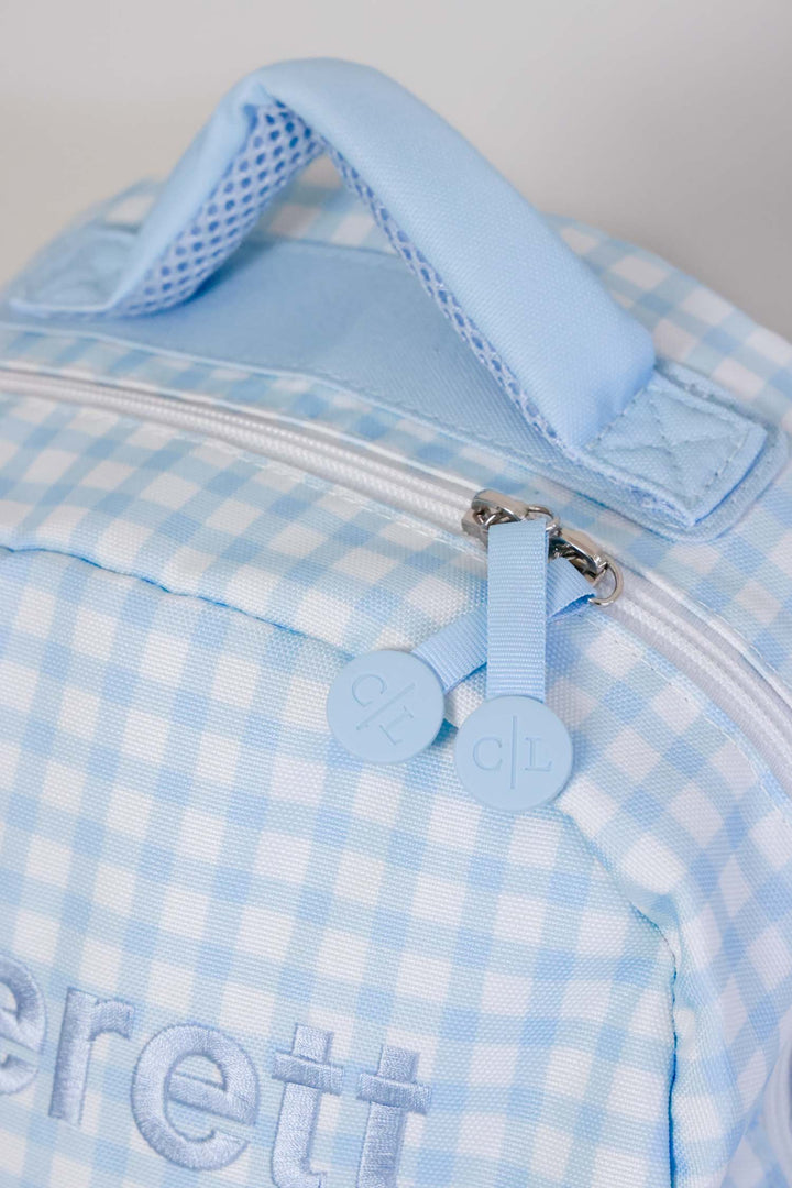 closeup of zipper on blue gingham embroidered backpack