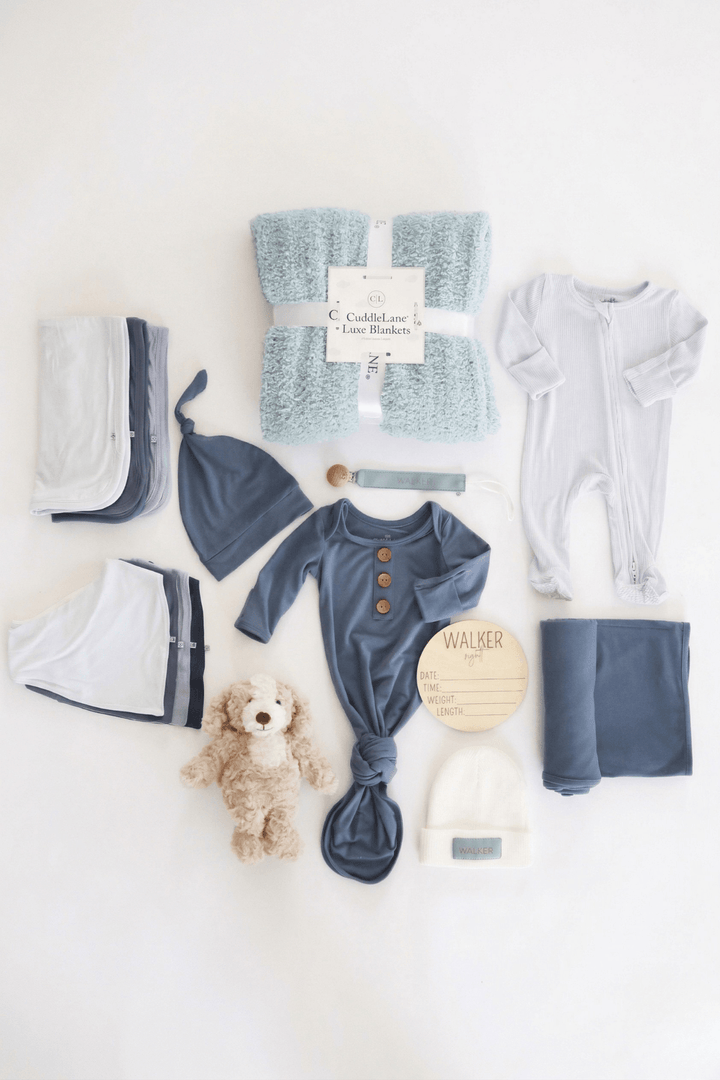 baby shower gift box bundle with blue pajamas, blankets, burps, and stuffed toy animal for boy