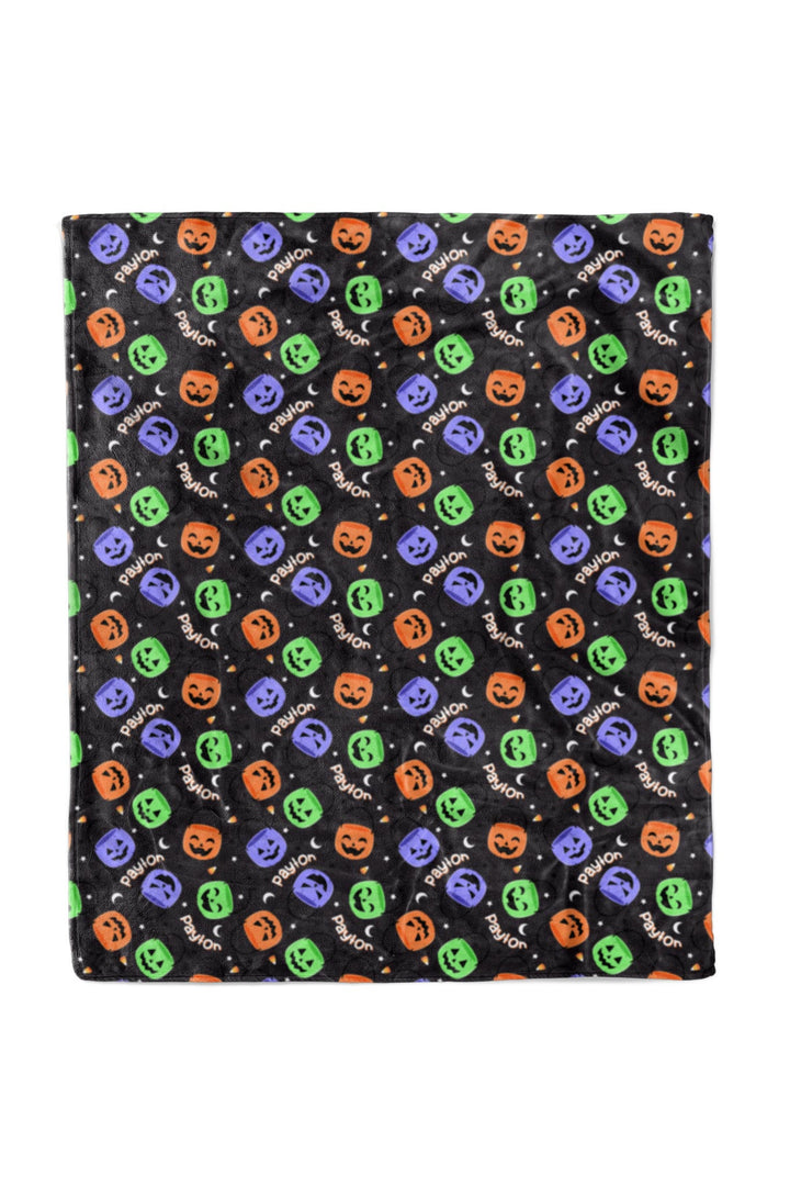 Personalized Halloween blanket, 50x60, in black fleece with repeating colorful jack-o-lantern print and custom name text