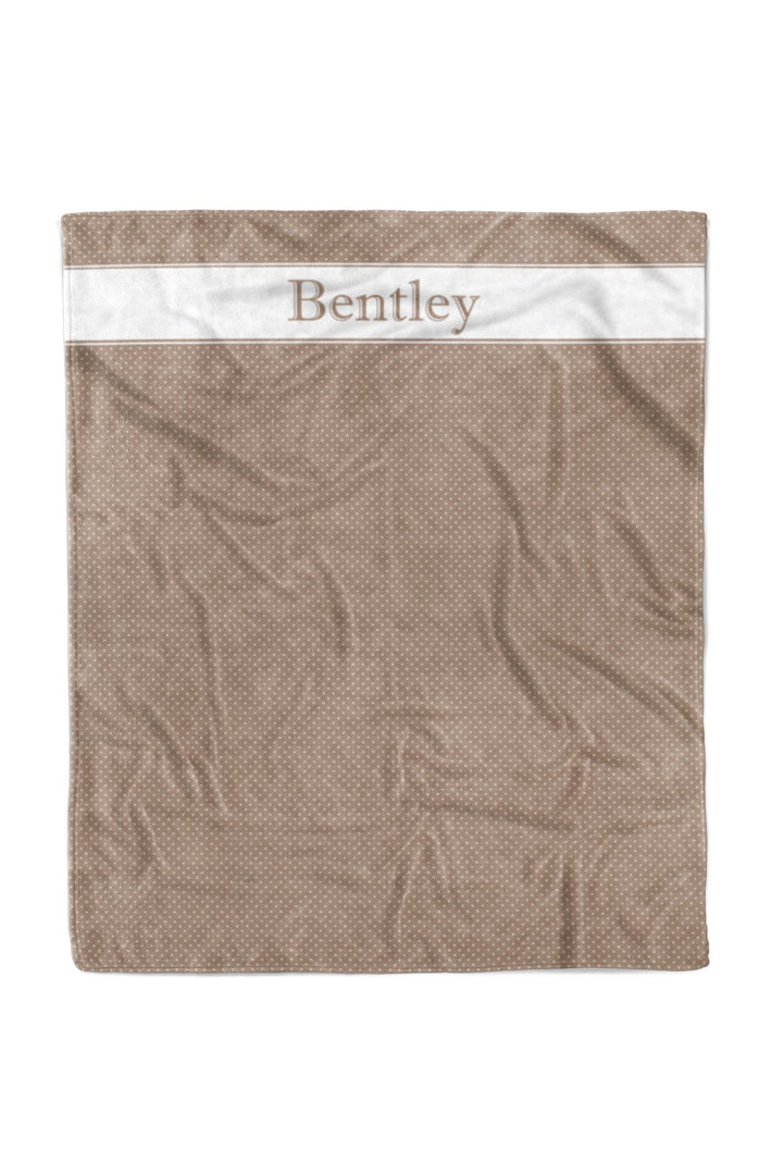 Personalized latte brown polka dot pet blanket with white satin border and the name 'Bentley' printed across the top