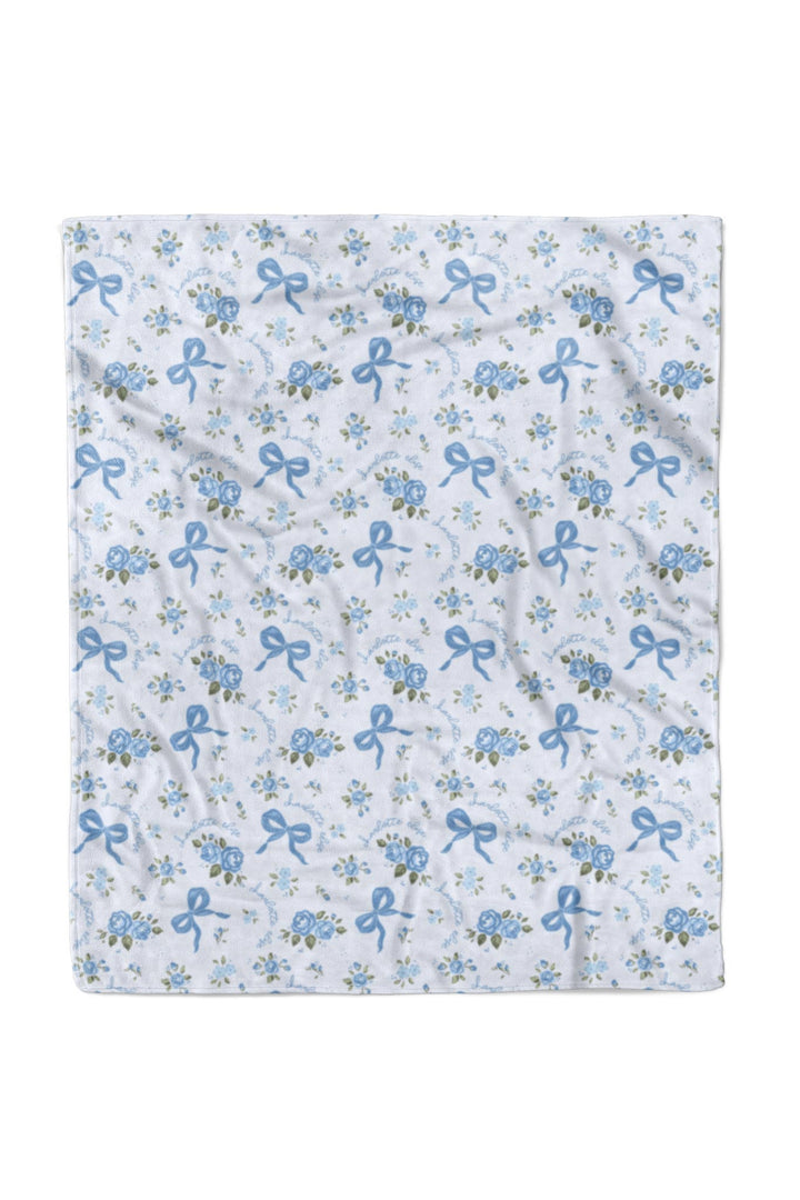 Flat lay of the 50x60 Tied In Blooms blanket fabric showing the blue floral and bow print pattern