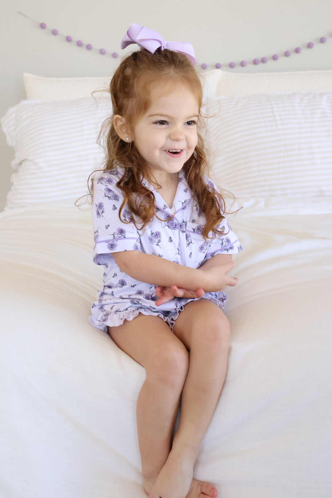 girl sitting on bed with ankles crossed in amethyst garden short lounge set 