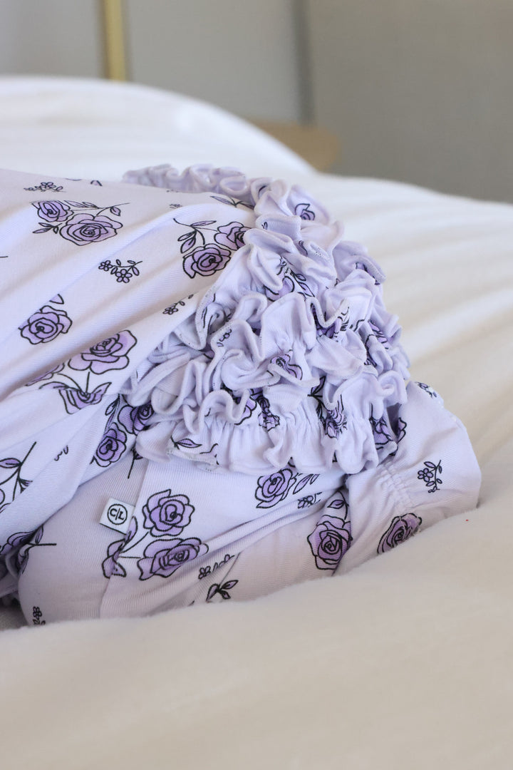 ruffle bottom zipper footie for girls in purple rose print 