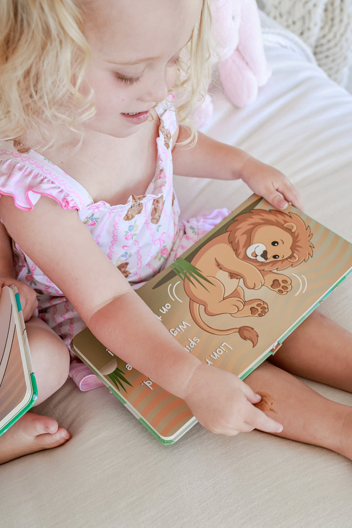 Young child reading Little Lion's Roooar Cuddle Plush Friends Story Book with 3D plush tail