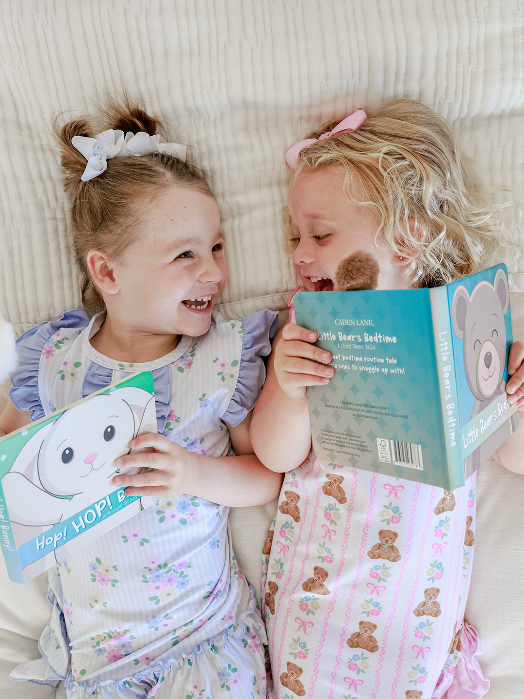 Three young girls lying on a bed reading Cuddle Plush Friends Story Books by Parker Puppy, Hop HOP Bunny, and Rory Lion