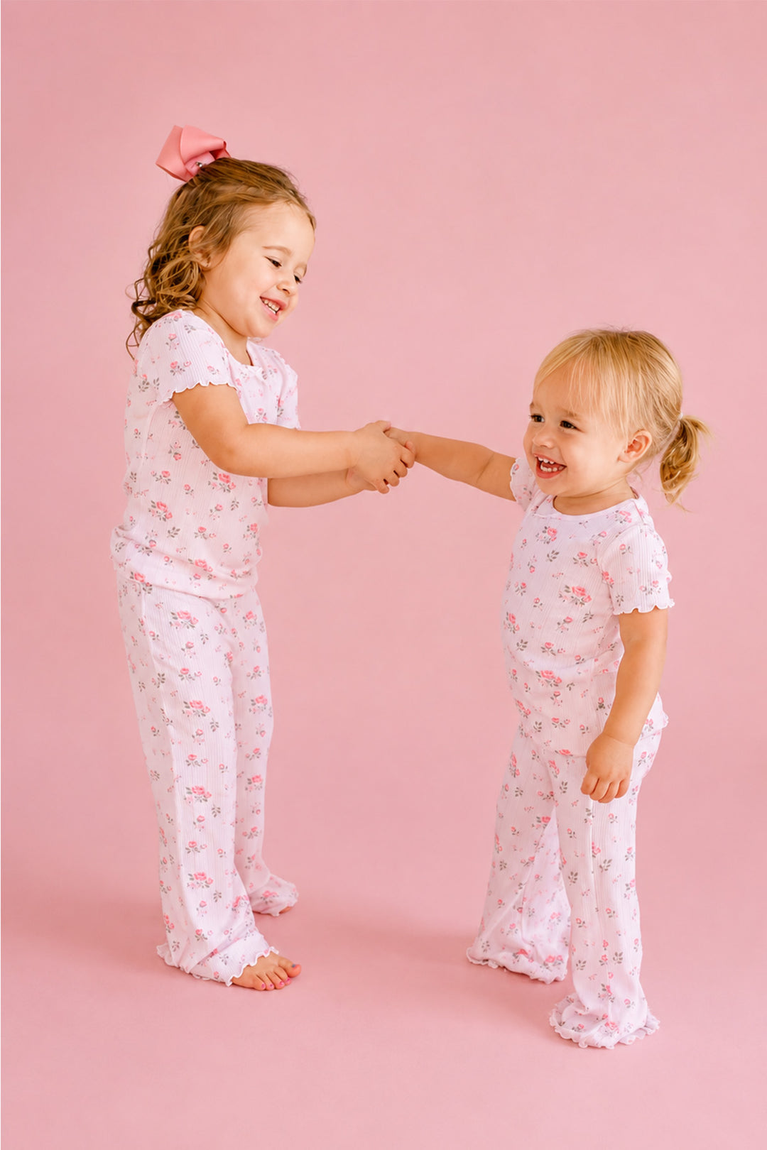 Caden Lane Rose Garden matching pajamas, two sisters holding hands in white floral pointelle pajama sets