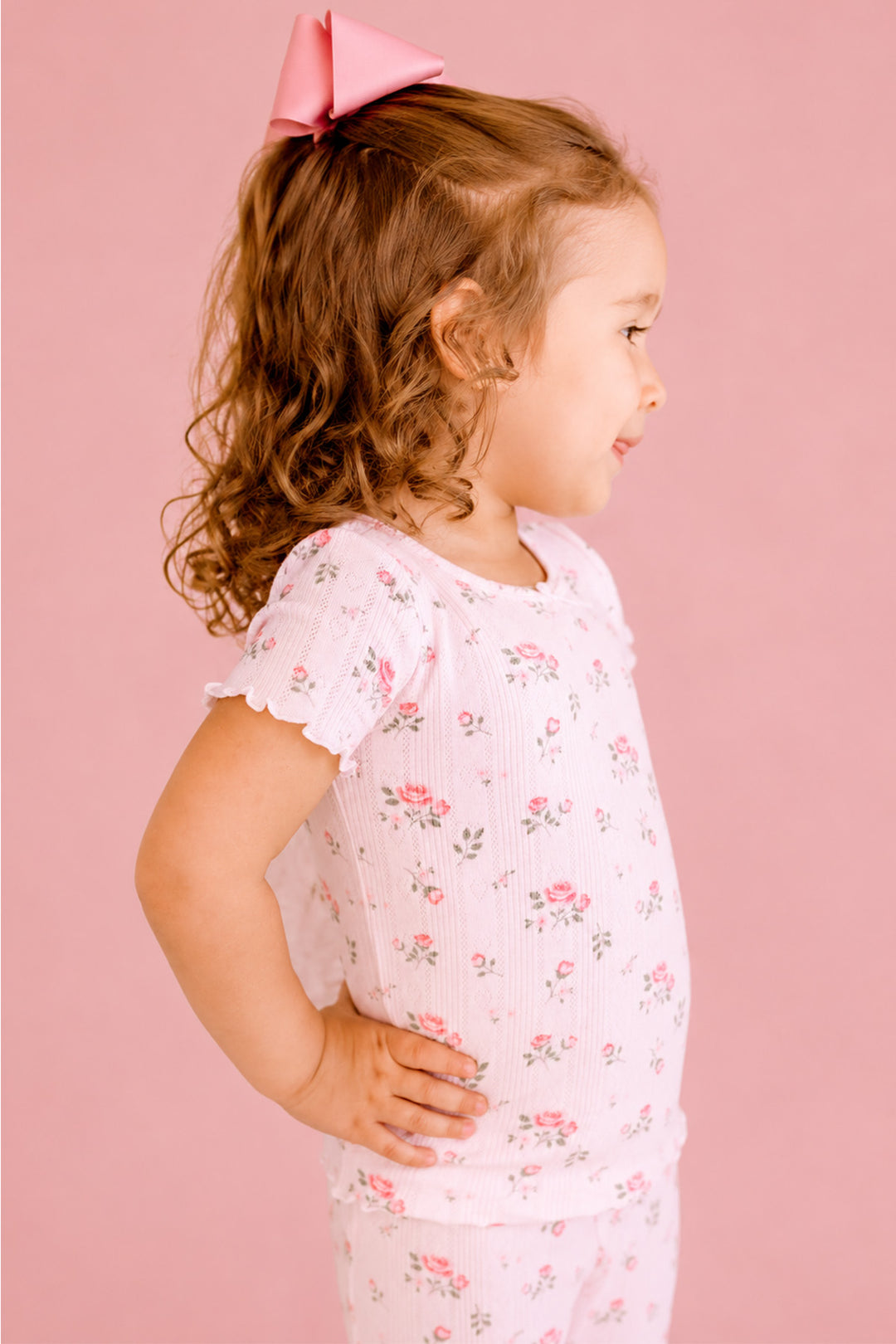 Caden Lane Rose Garden pajama set, toddler girl in white floral pointelle pajamas, side profile
