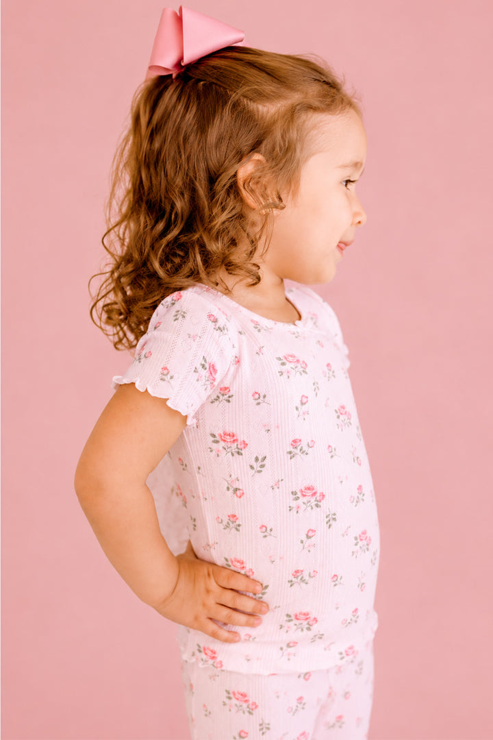 Caden Lane Rose Garden pajama set, toddler girl in white floral pointelle pajamas, side profile