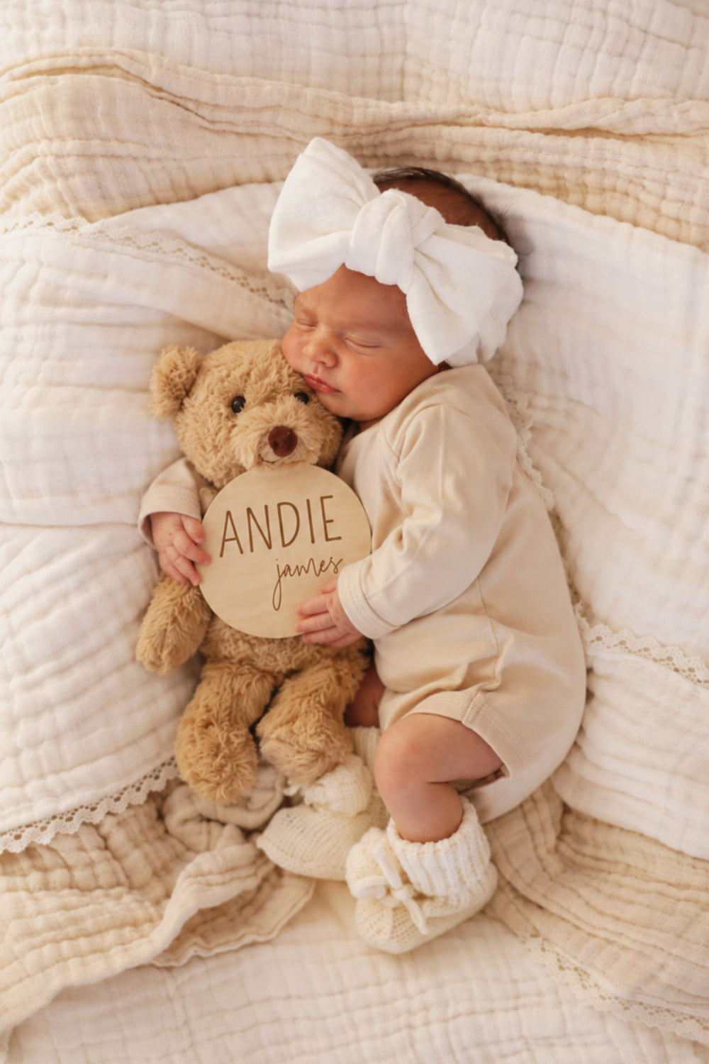 newborn holding teddy bear and wood name announcement block and script font