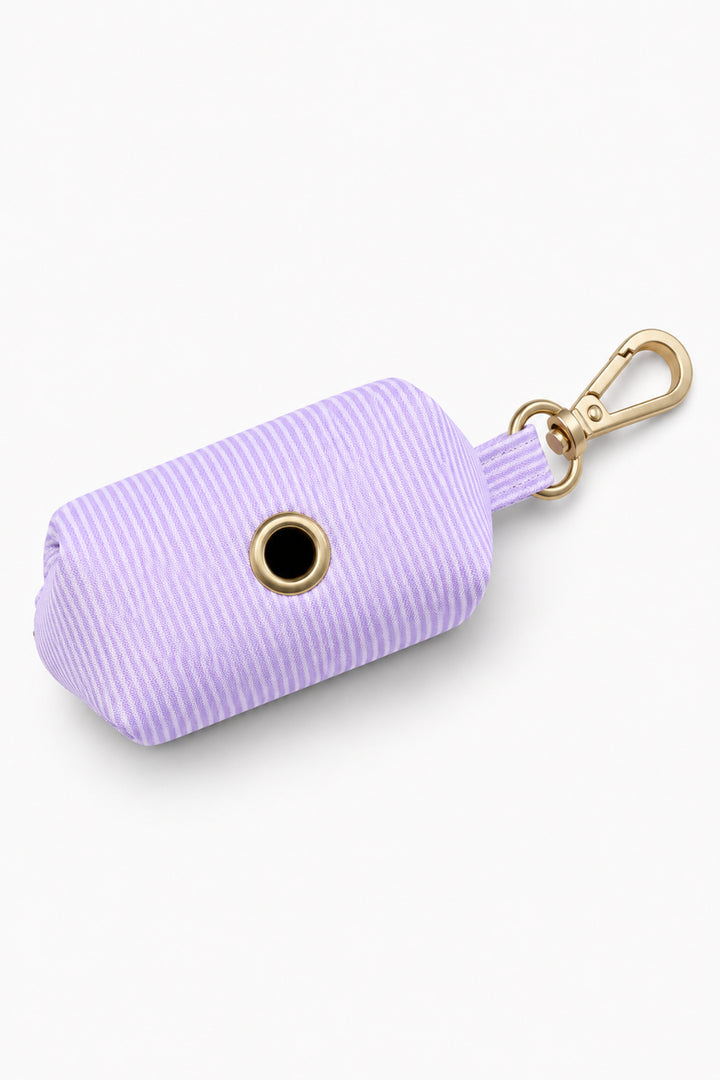 Bottom view of the lavender woven waste bag holder showing the circular bag dispensing hole and gold carabiner clip attachment