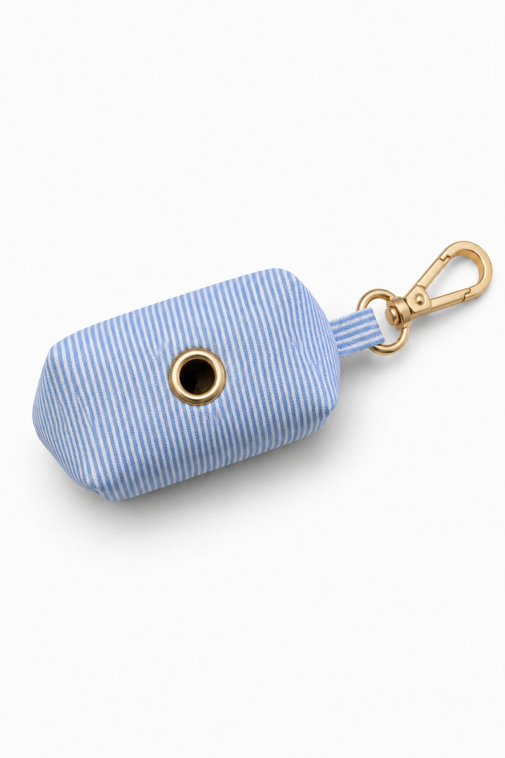 Bottom view of Morning Mist light blue and white striped pet waste bag holder showing dispensing opening and gold carabiner clip attachment