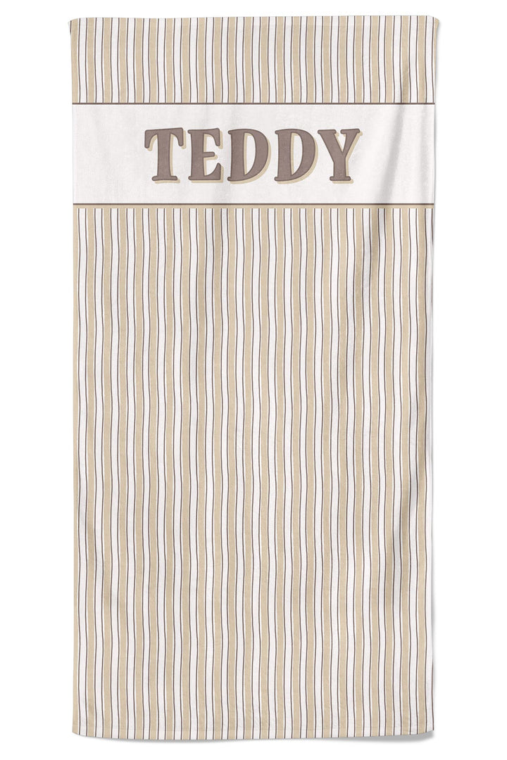 Flat-lay of personalized pet towel in Biscuit Stripe pattern with tan and white vertical stripes, featuring the name TEDDY embroidered on the white border at the top