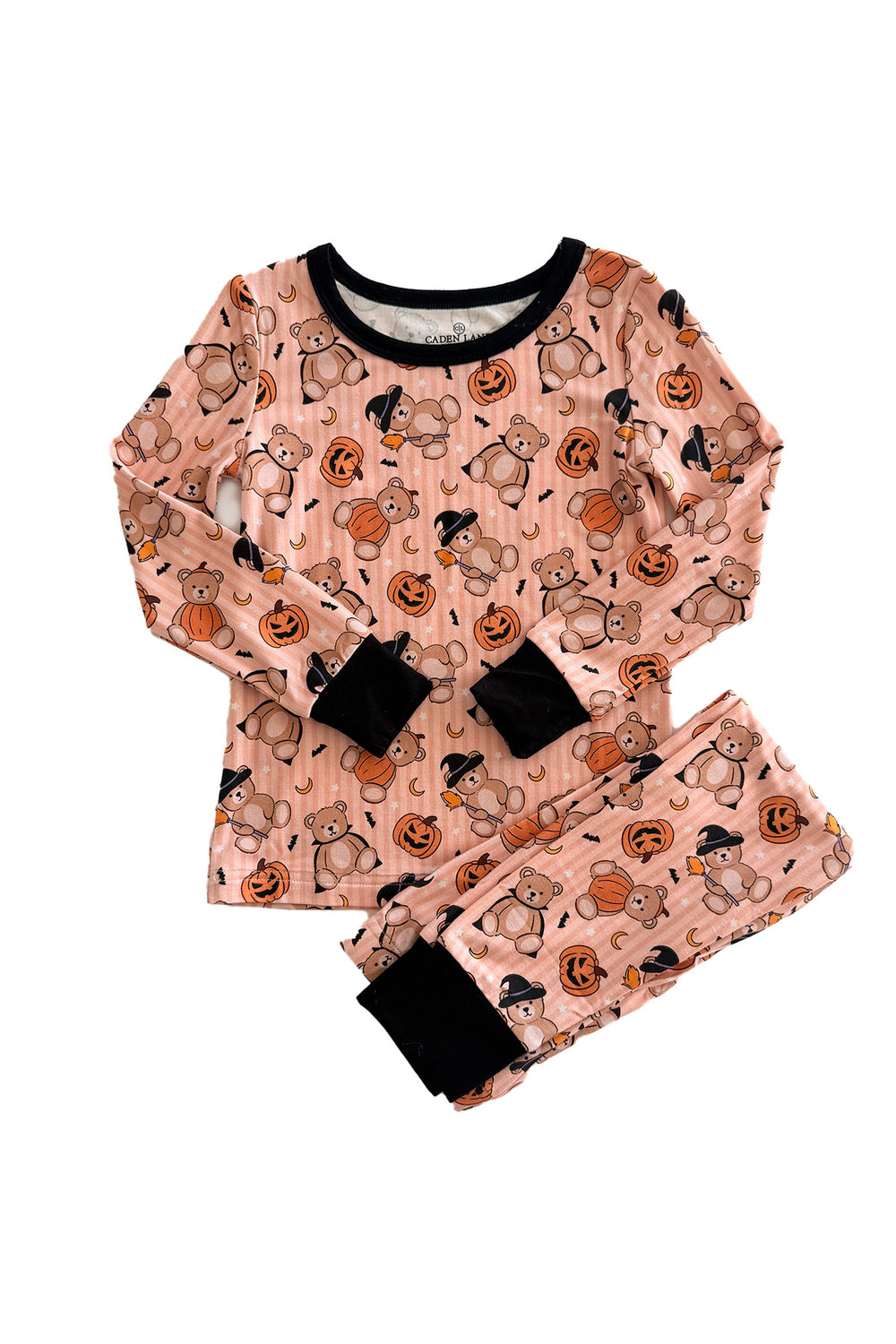 Caden Lane two-piece children's pajama set featuring a long-sleeve top and matching pants in an orange color with a Halloween print of teddy bears, pumpkins, ghosts, and bats. The set has black ribbed trim at the collar, cuffs, and pant cuffs, and is laid flat on a white background.