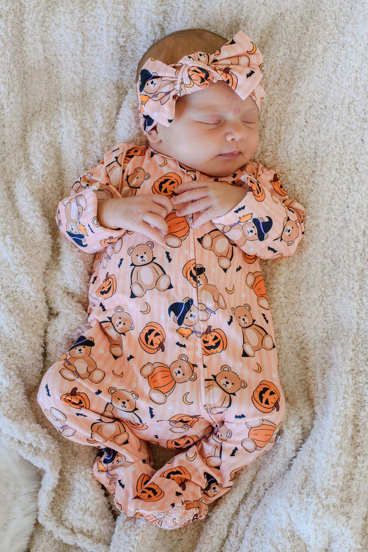 baby laying on blanket in beary scary zipper footie in halloween print 