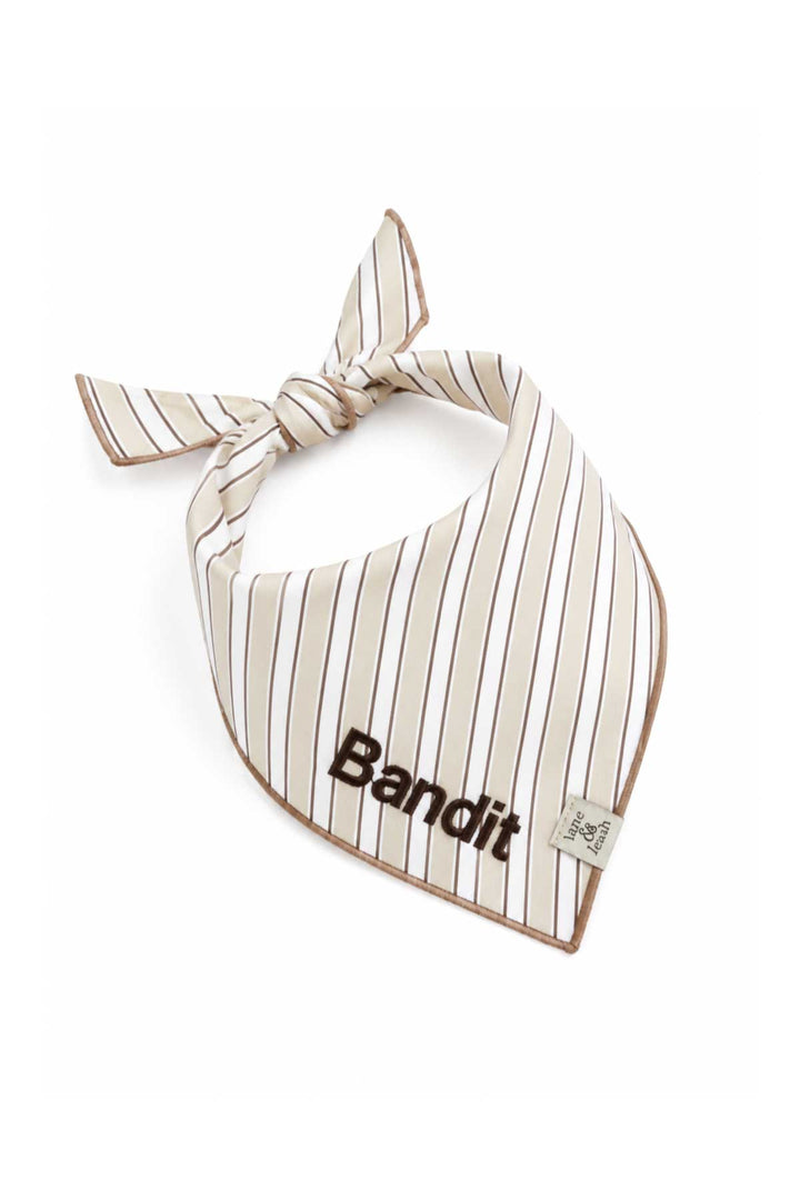 Embroidered pet bandana in Biscuit Stripe pattern tied in a knot, with the name Bandit stitched in bold block letters on the front