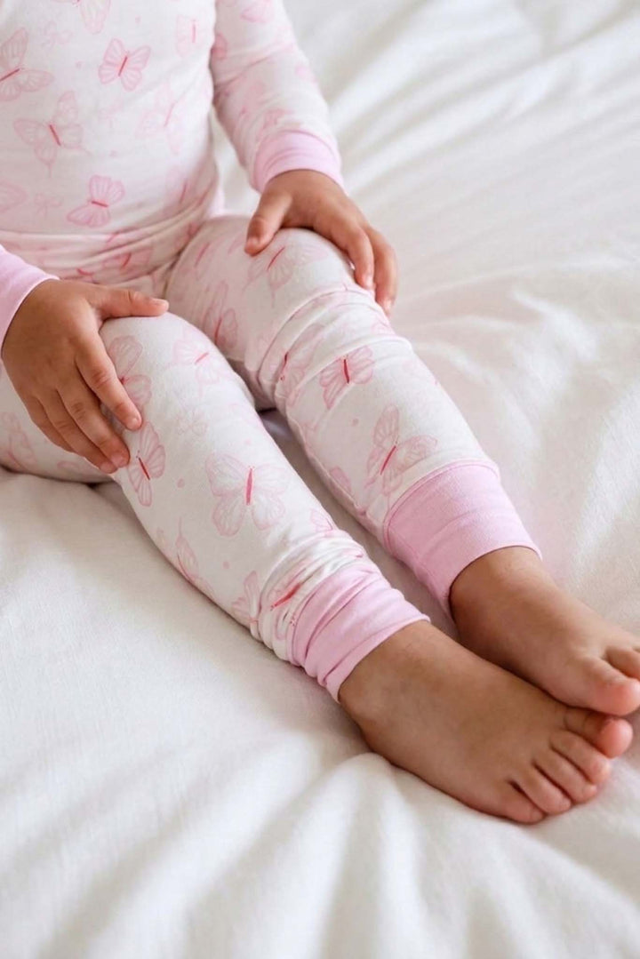 Two Piece Pajama Set in Blooming Butterflies print - close-up of toddler's legs in the butterfly-print pajama pants showing the pink cuffed ankles and soft fabric texture