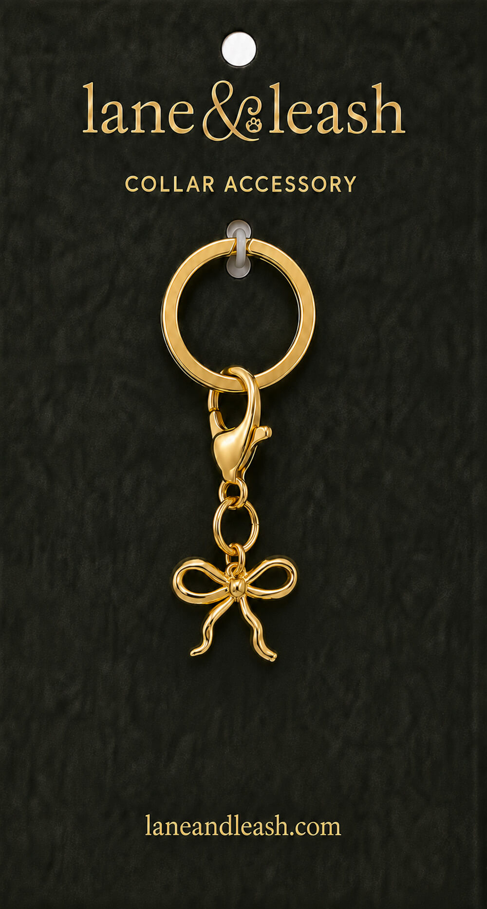 Gold bow Lane & Leash collar accessory charm displayed on dark green packaging card with lobster claw clasp and jump ring