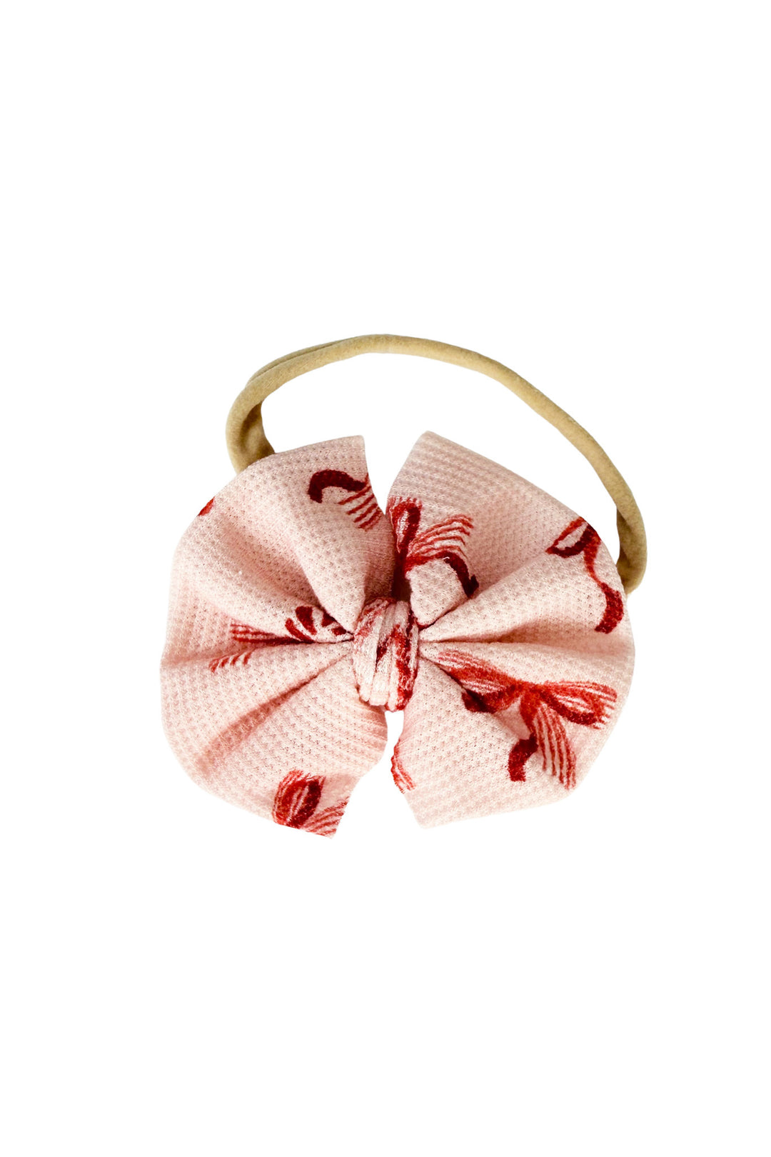 Caden Lane Peppermint Bows baby bow headband in soft pink with a festive red ribbon bow print and stretchy nylon band.