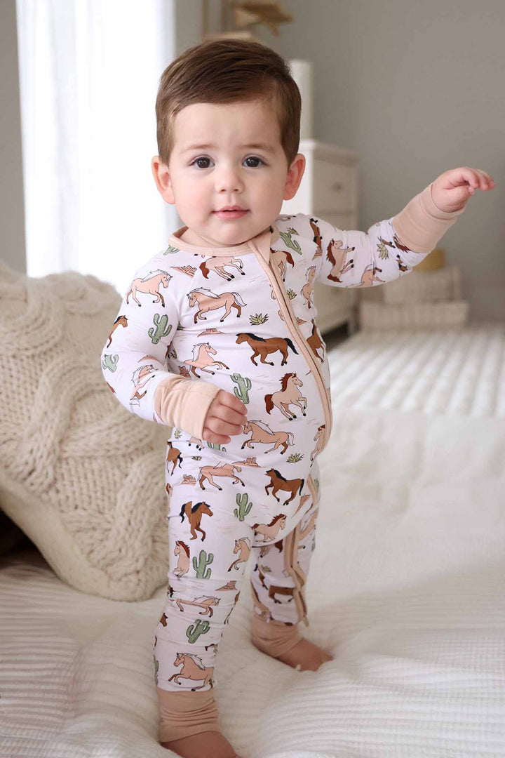 standing baby boy in brown and green horse and cactus zip romper pajama 