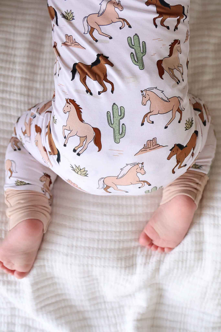 closeup of neutral pony club print convertible zip romper