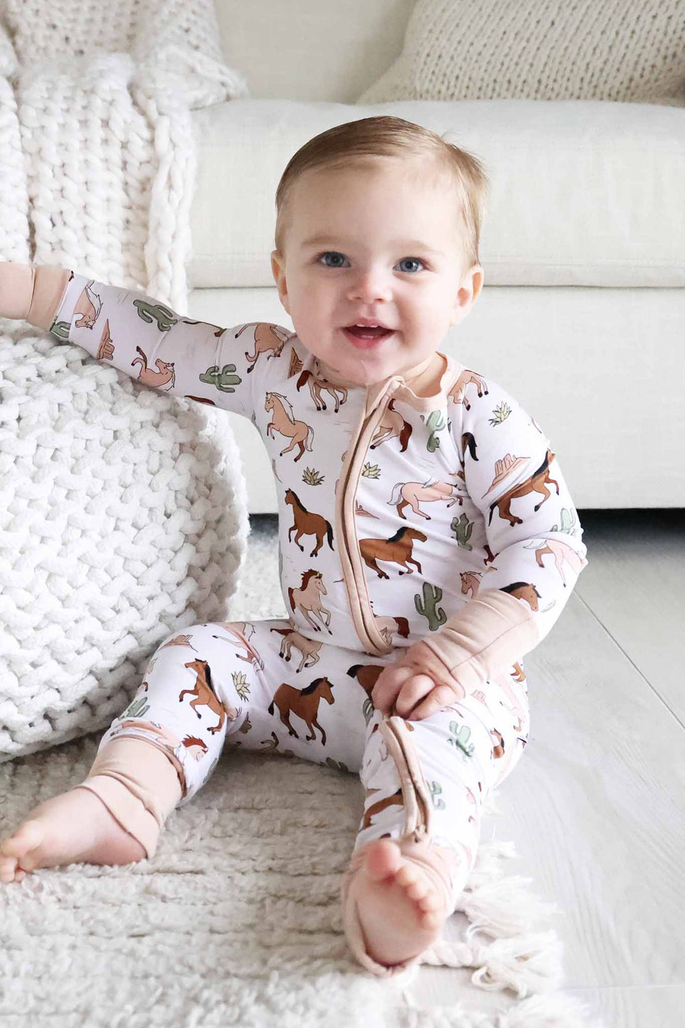 sitting baby boy in neutral pony club convertible zip romper 