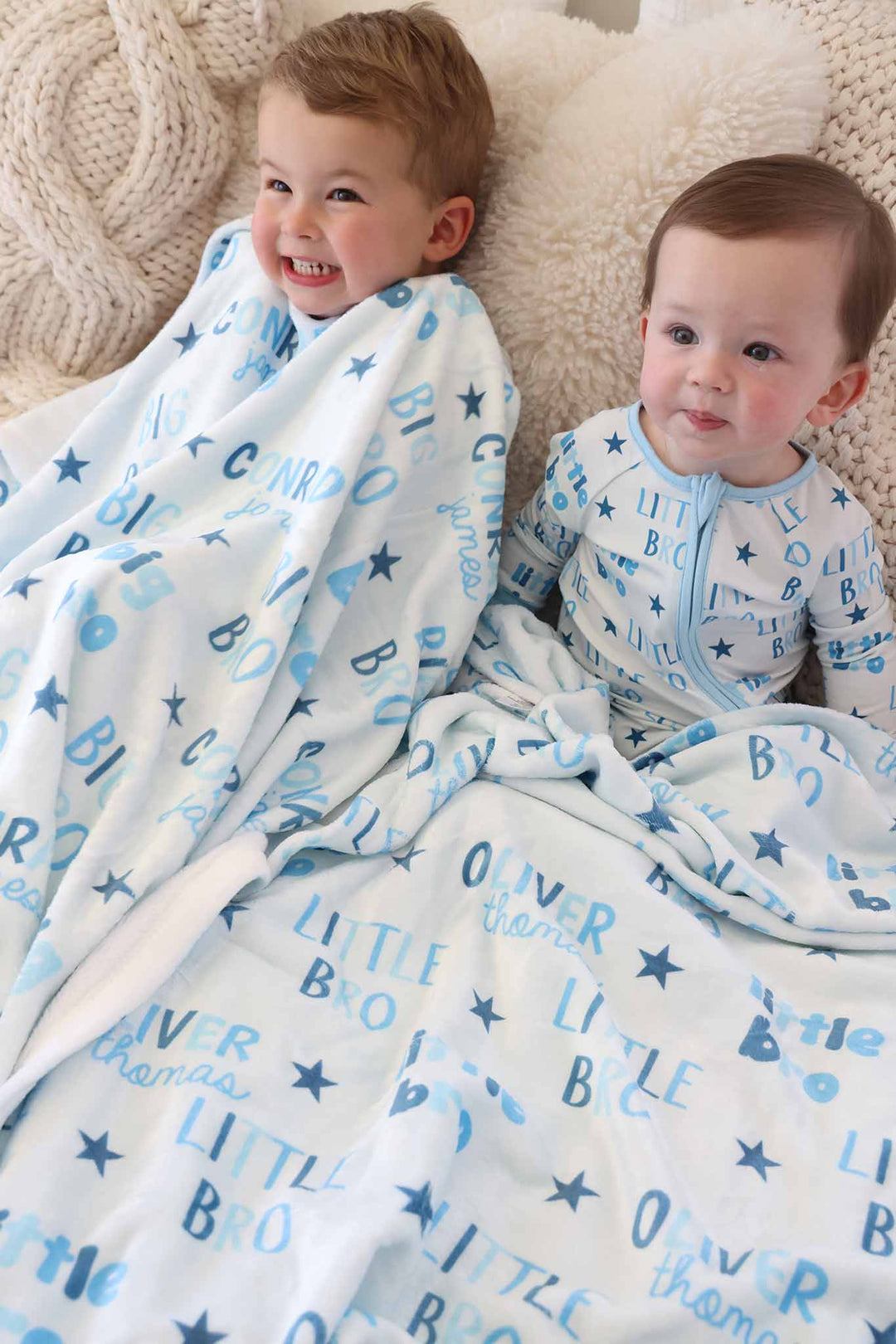 brothers laying on bed with matching personalized blankets 