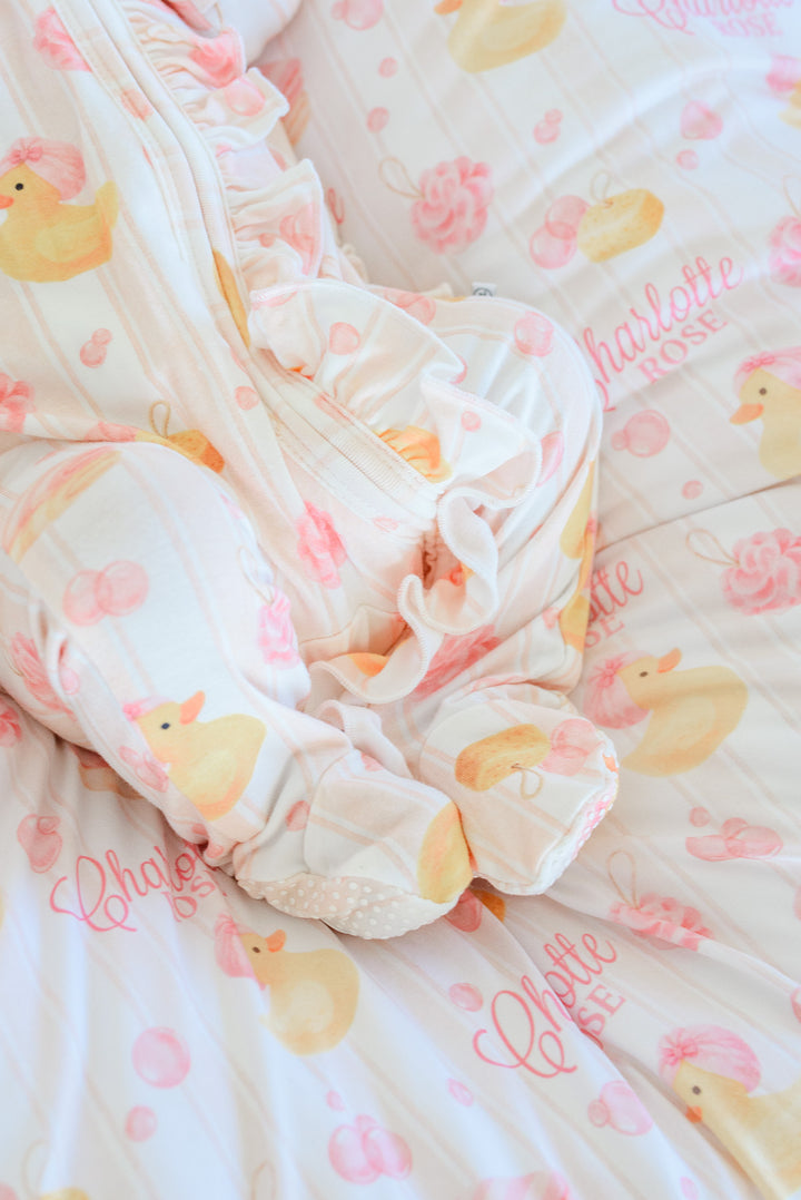 Close-up detail of newborn in pink Bubble Duckies zipper footie on personalized rubber duckie blanket