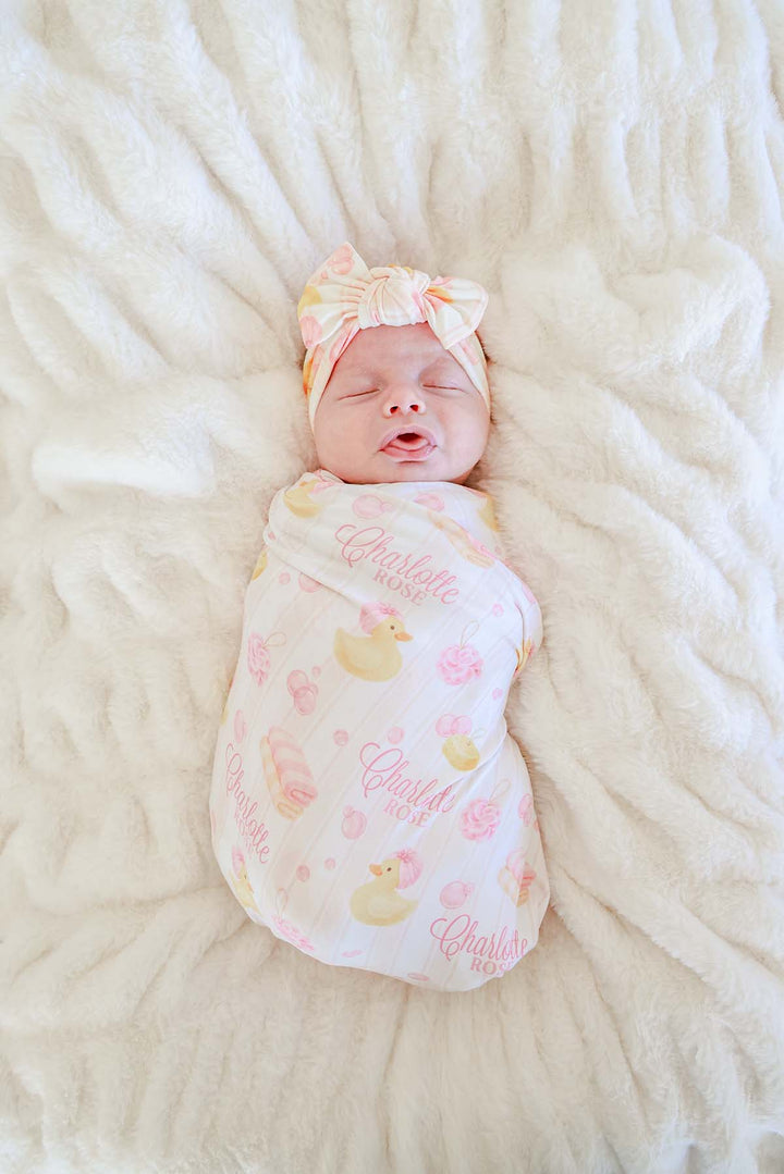 baby girl wrapped in pink bubble duckies personalized swaddle blanket