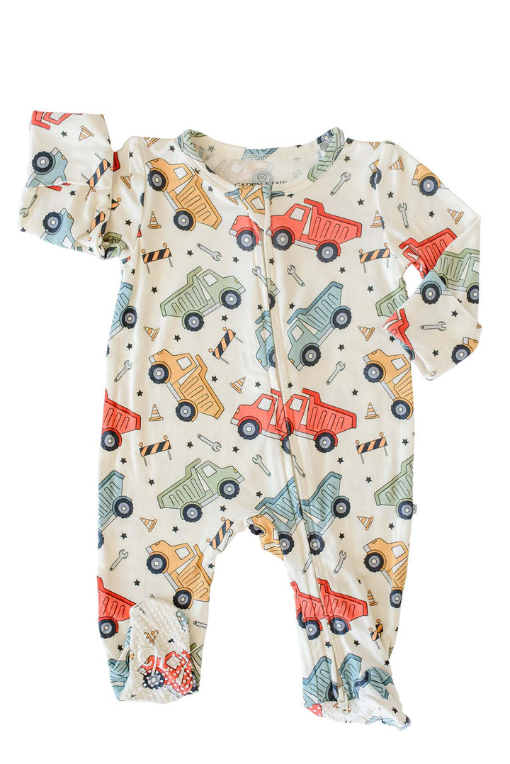 Flat lay of a Caden Lane cream knit footed zip sleeper in a Busy Builder print featuring dump trucks and wrenches, with fold-over mitten cuffs and grippy soles.