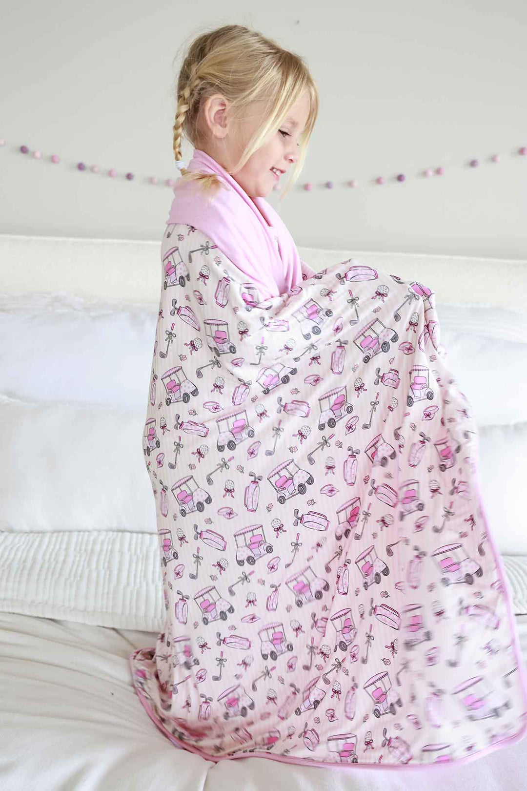 girl wrapped up in pink golf bamboo blanket