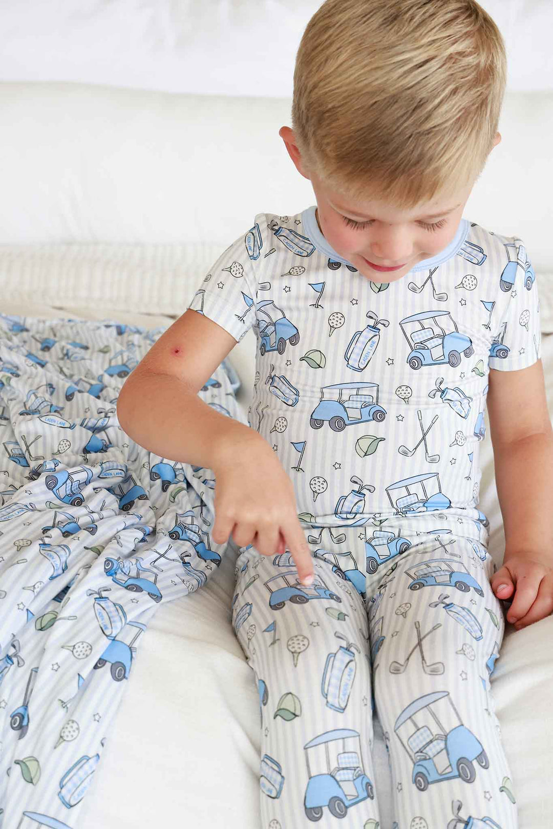 boy pointing to pants in golf pajamas