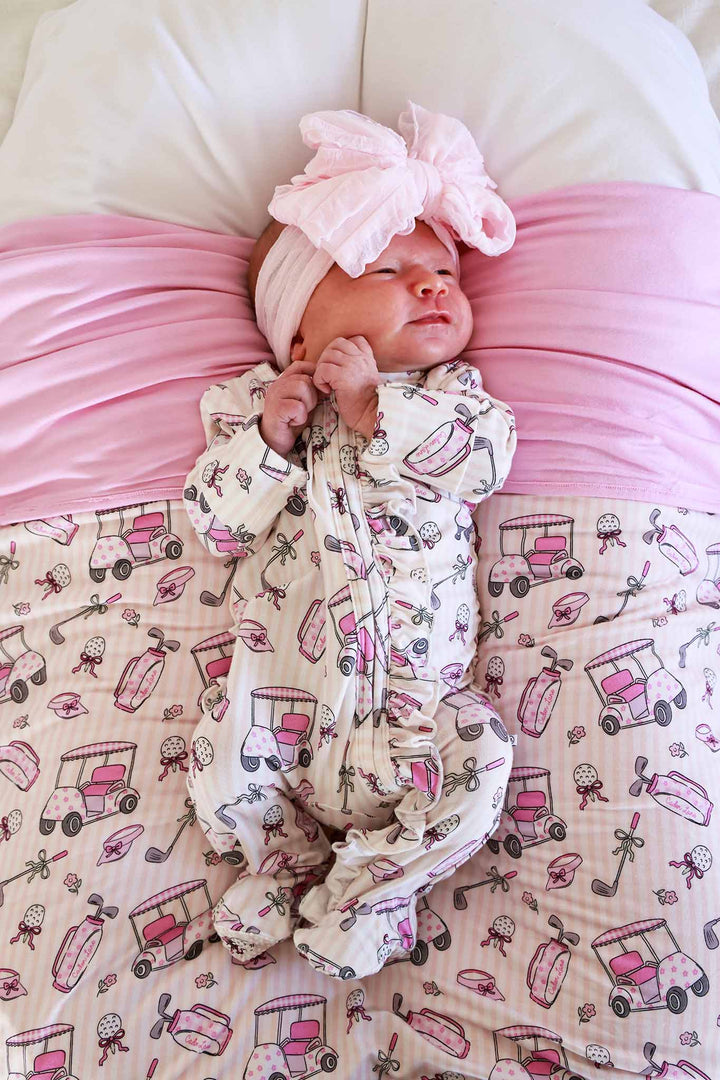 baby girl laying on lounger in caddie crew pink ruffle zipper footie