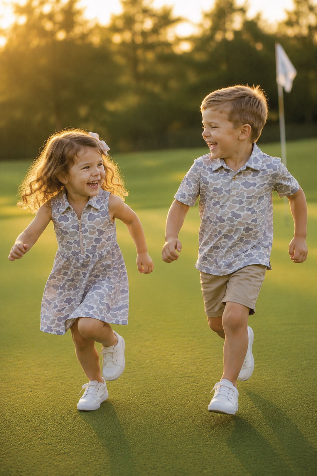 brother and sister running on golf course in matching polo outfits