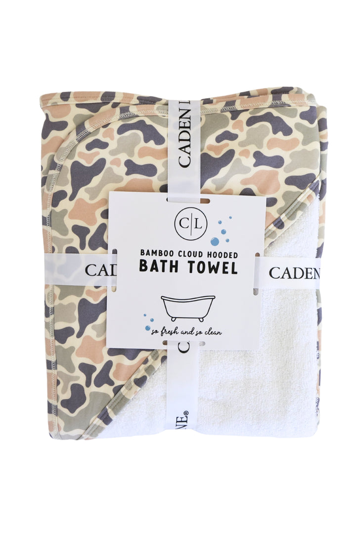 Caden Lane Bamboo Cloud Hooded Bath Towel folded flat showing camo print in tan, brown, and gray with product tag