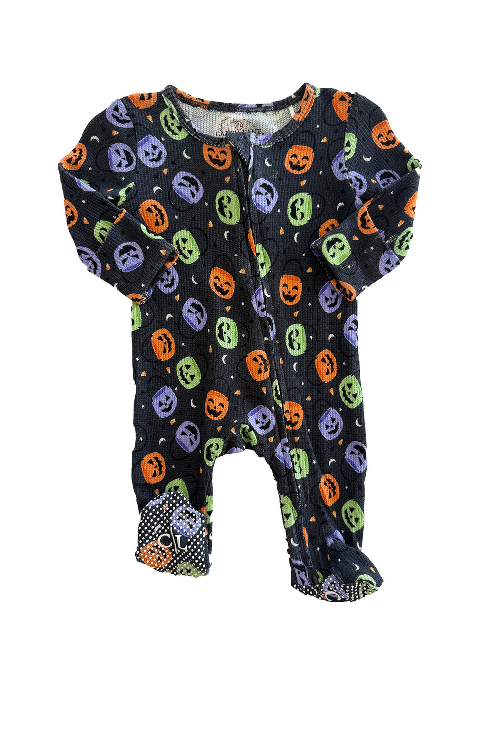 Bamboo waffle zipper footie in black with colorful jack-o-lantern print and polka dot footed bottoms, laid flat