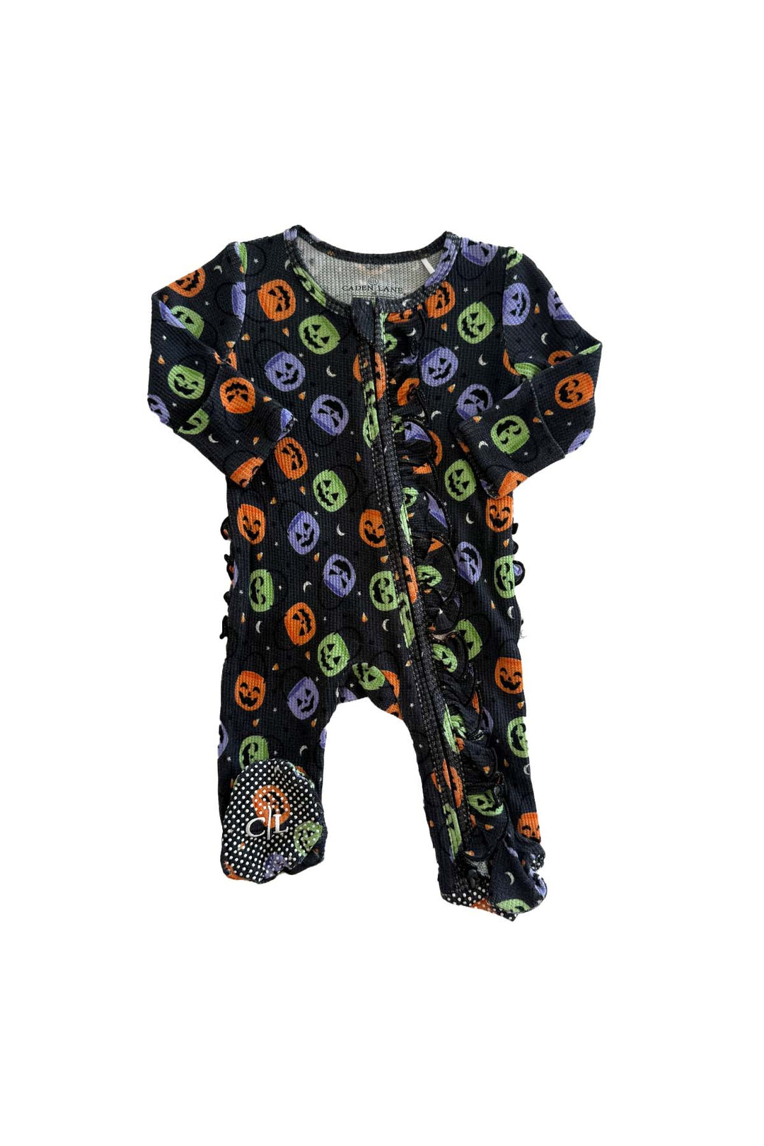 Bamboo waffle ruffle zipper footie in black with colorful jack-o-lantern print and polka dot footed bottoms, laid flat