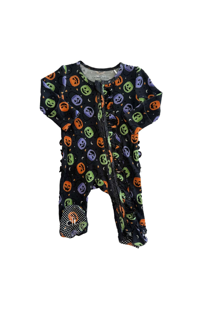 Bamboo waffle ruffle zipper footie in black with colorful jack-o-lantern print and polka dot footed bottoms, laid flat