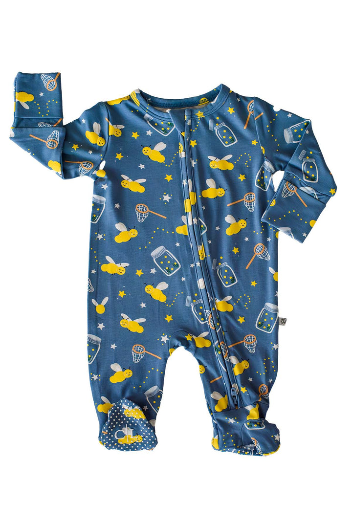 Flat lay of a Caden Lane blue bamboo zipper footie in a Chasing Fireflies print featuring fireflies and mason jars, with one sleeve raised and polka-dot feet.