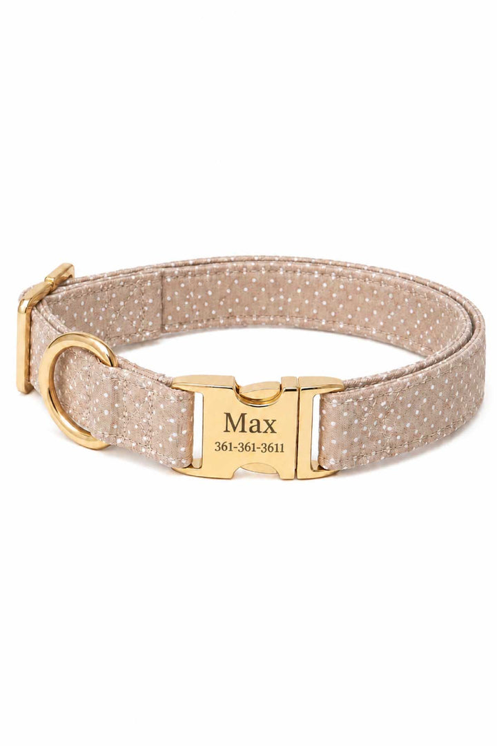 Latte brown polka dot dog collar with gold quick-release buckle and a personalized gold ID tag engraved with a name and phone number