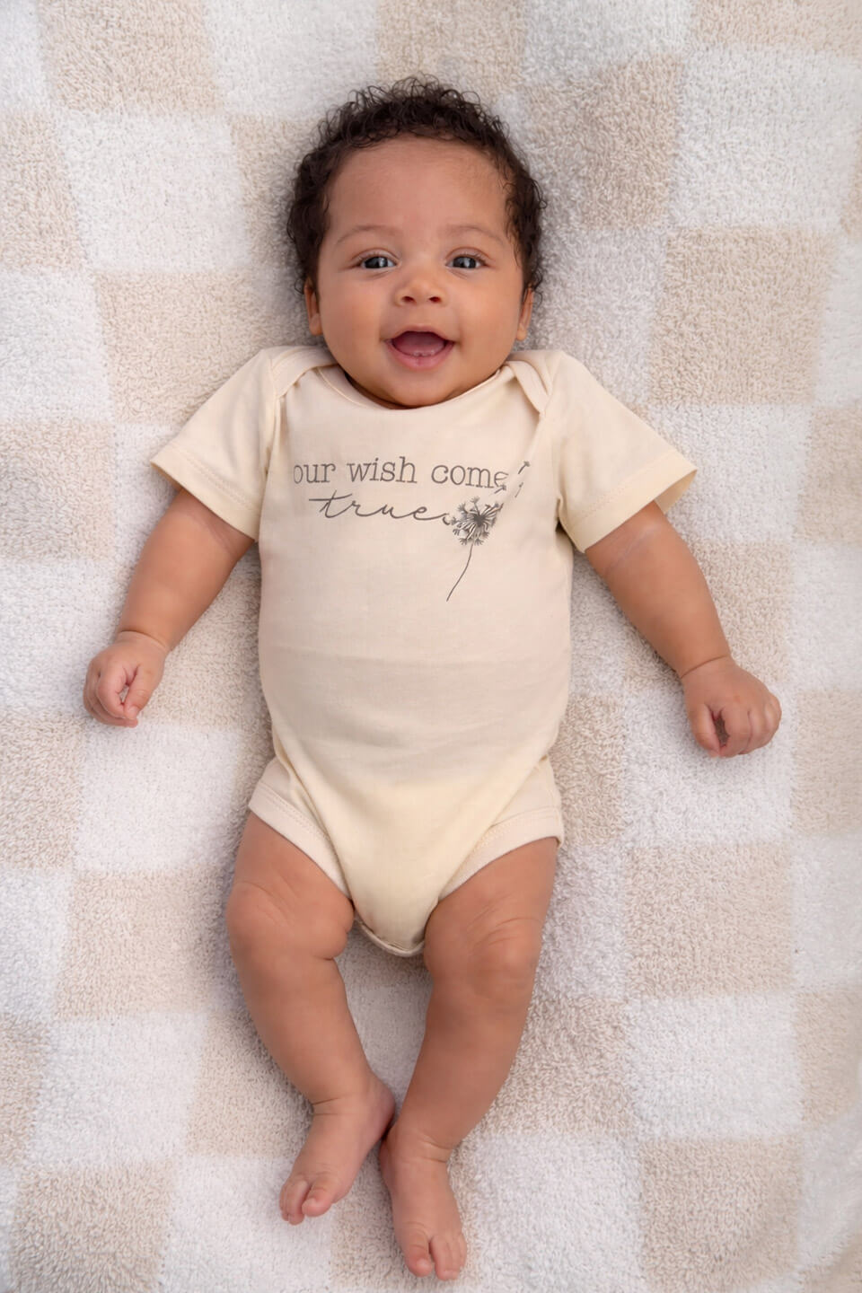 baby wearing our wish come true graphic cotton bodysuit in natural, conceive fertility foundation