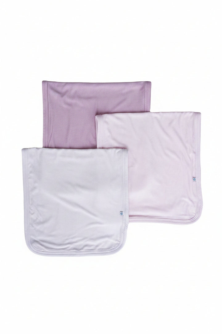 Three Caden Lane folded baby burp clothes in soft shades of purple.