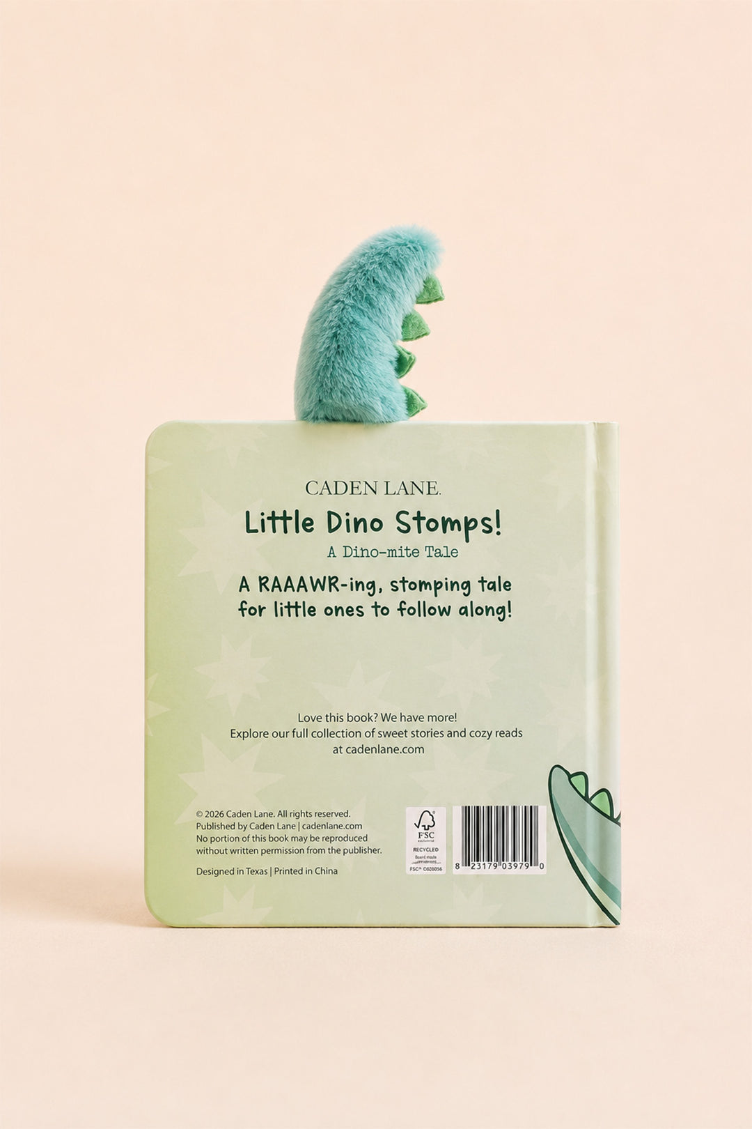 The back cover of a children's book titled 'Little Dino Stomps!' by Caden Lane, featuring a light green cover with a plush green dinosaur peeking out from the top, set against a solid pale peach background.