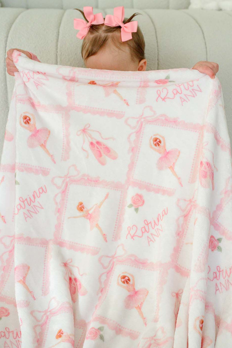 Baby girl sitting with a matching personalized plush blanket embroidered with her name