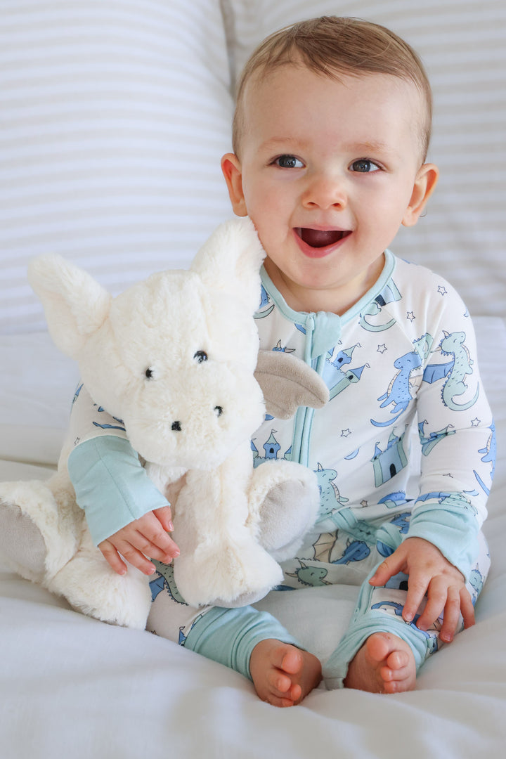 boy holding a white dragon stuffed animal 