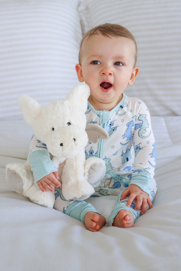 yawning boy holding a dragon stuffed animal 